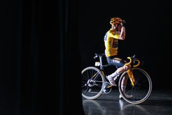 cyclist in yellow in black room