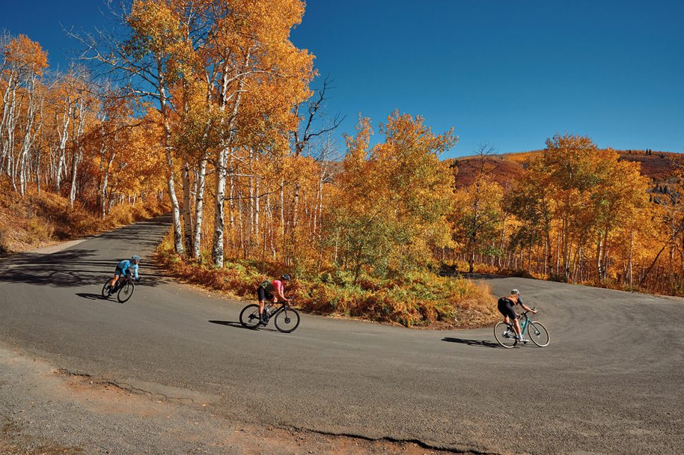 Cyclists descending round bend with beautiful autumn colours