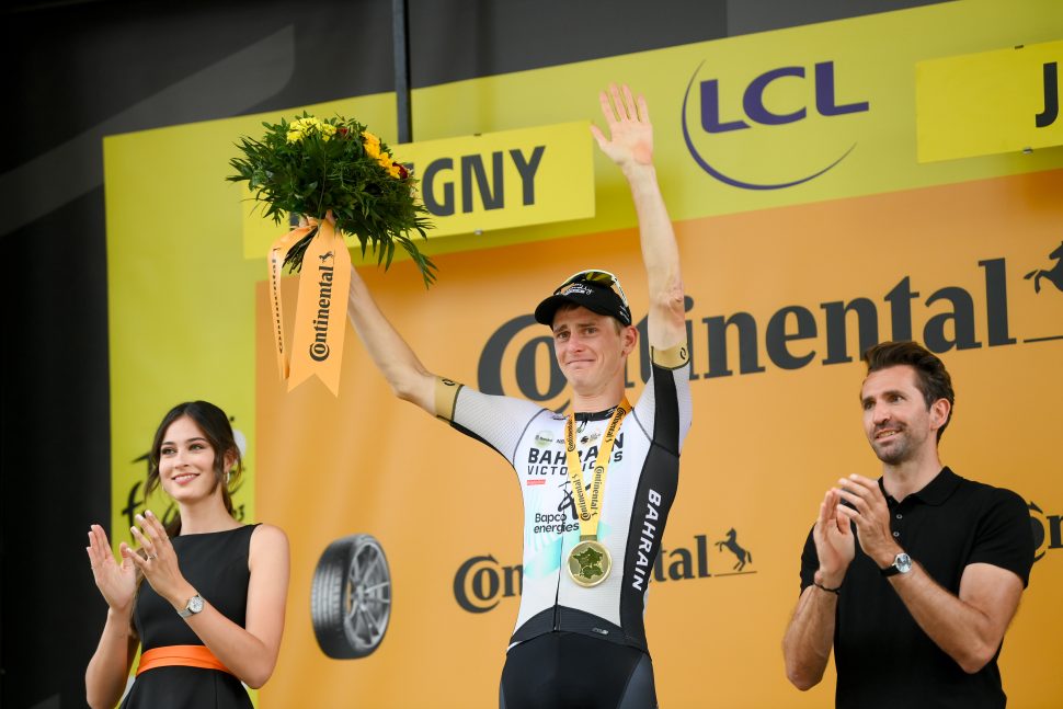 cyclist in white holds back tears on podium