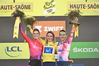 women on podium in cycling kit celebrating